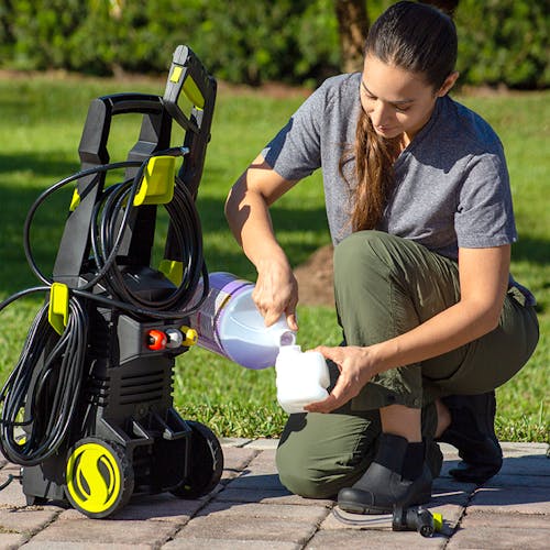 Woman refilling the detergent tank for the Sun Joe 13-amp 2080 PSI Electric Pressure Washer.