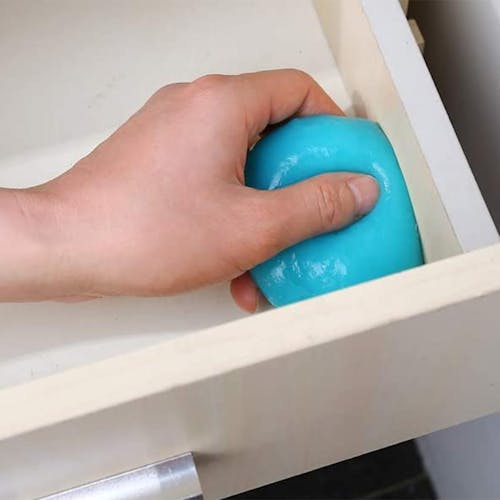 Auto Joe Reusable Multi-Purpose Cleaning Gel being used to clean the inside corner of a drawer.