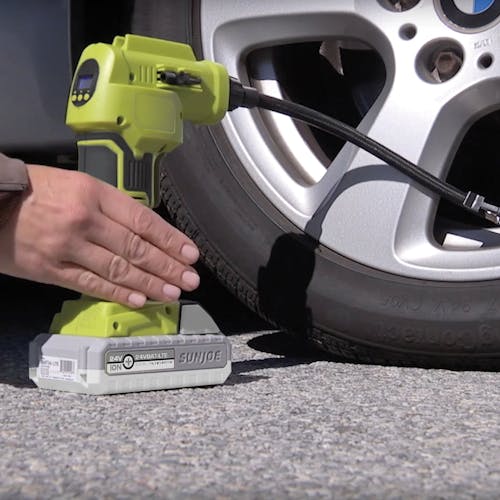 Person using the Auto Joe 24-Volt Cordless Portable Air Compressor Kit to fill their car tire with air.