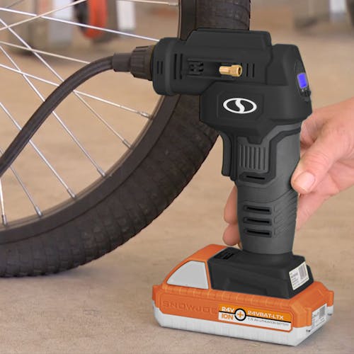 Person using the Sun Joe 24-Volt Cordless Portable Air Compressor in black with a 1.5-Ah lithium-ion Battery attached to fill up a bike tire.