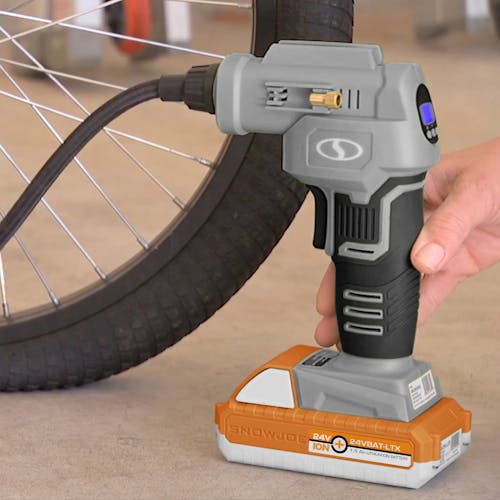 Person using the Sun Joe 24-Volt Cordless Portable Air Compressor in gray with a 1.5-Ah lithium-ion Battery attached to fill up a bike tire.