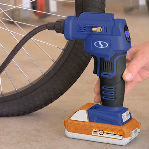 Person using the Sun Joe 24-Volt Cordless Portable Air Compressor in blue with a 1.5-Ah lithium-ion Battery attached to fill up a bike tire.
