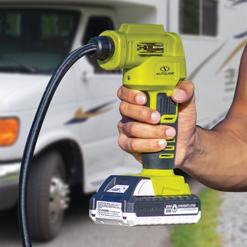 Person holding the Sun Joe 24-Volt Portable Cordless Air Compressor with a 1.3-Ah lithium-ion battery attached.
