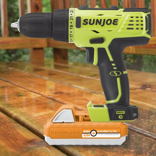 Side view of the Sun Joe 24-volt Cordless Drill Driver with a 1.5-Ah lithium-ion battery attached on a patio.