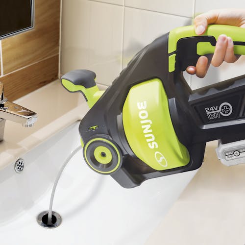 Person dumping water into the sink from the Sun Joe 24-volt Cordless Automatic Drain Auger.