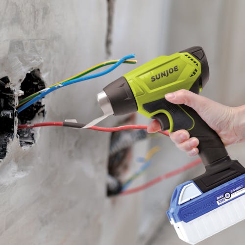Person using the Sun Joe 24-volt cordless Heat Gun to assist with electrical work.