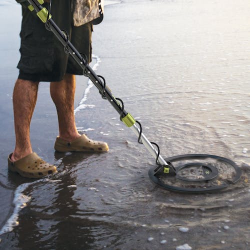 Person using the Sun Joe 24-volt cordless 10-inch metal detector in shallow water.