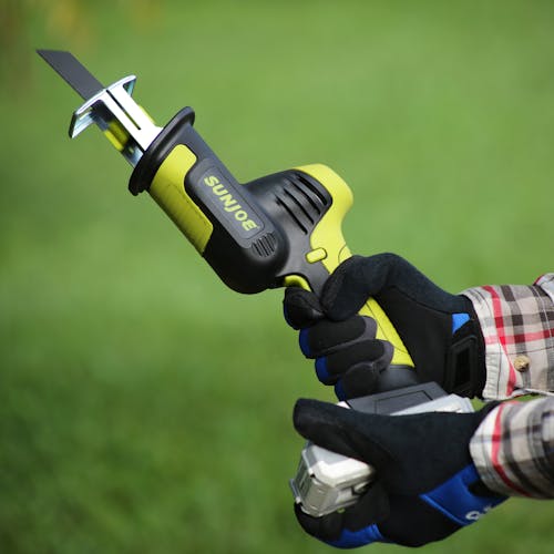 Person holding the Sun Joe 24-volt Cordless All-Purpose Reciprocating Saw Kit with the metal cutting blade.
