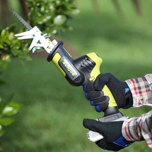 Person holding the Sun Joe 24-volt Cordless All-Purpose Reciprocating Saw Kit with the wood cutting blade.