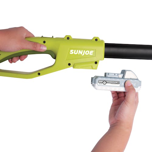 Person putting a 2.0-Ah lithium-ion battery onto the Sun Joe 24-volt cordless telescoping pole 8-inch chainsaw.
