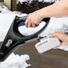 Person putting a 5.0-Ah lithium-ion battery onto the Snow Joe 24-volt cordless 12-inch snow shovel kit.