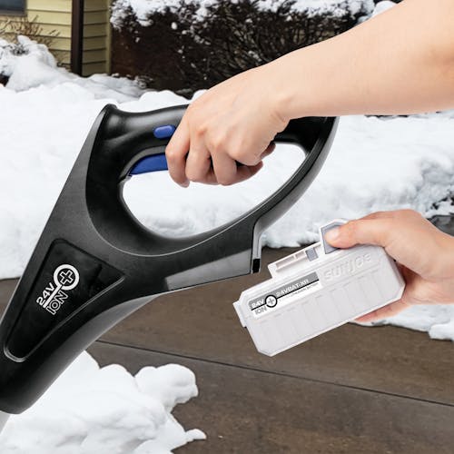 Person putting a 5.0-Ah lithium-ion battery onto the Snow Joe 24-volt cordless 12-inch snow shovel kit.