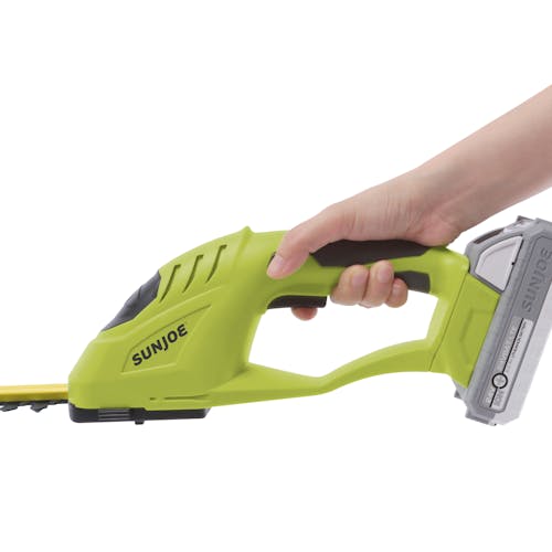 Side view of the Sun Joe 24-volt Cordless handheld shrubber and trimmer with a 2.0-Ah lithium-ion battery attached.