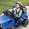 Young boy smiling while wearing a helmet and driving the Snow Joe 24-Volt Ride On Kids Truck in a driveway.