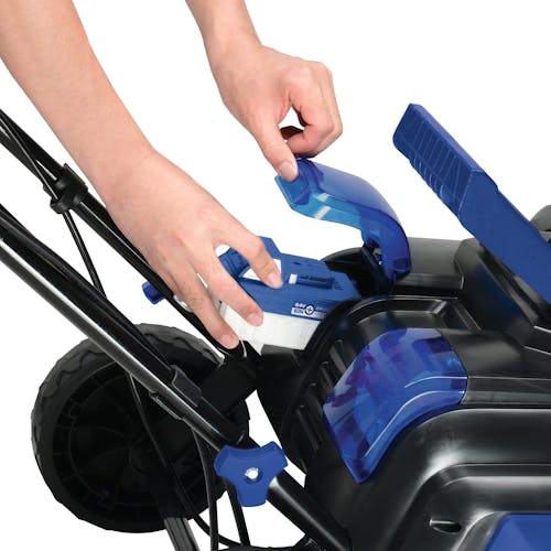 Person inserting a 4.0-Ah lithium-ion battery into the Snow Joe 48-volt cordless snow blower kit with auto-rotate chute.