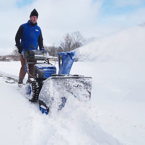 man blowing snow using snow joe cordless 96 volt snowblower