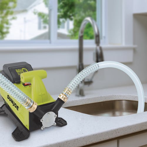 Sun Joe 24-volt Cordless 5.0-GPM Transfer Pump with a 2.0-Ah lithium-ion battery transferring water from the sink.