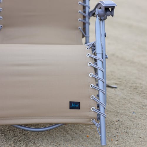 Close-up of the frame and bungees on the taupe beach recliner.