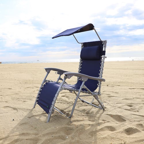 Navy beach recliner with canopy on the sand.
