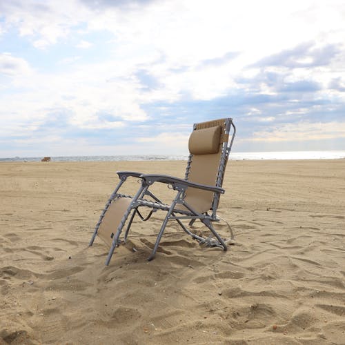Taupe beach recliner on the sand.
