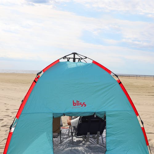 Rear view of the beach tent on sand with the back flap open.