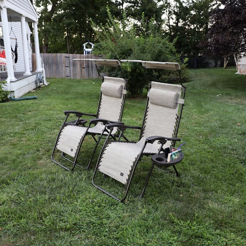 Angled view of a Set of 2 26-inch sand gravity free chairs placed on a lawn.