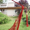 Close-up of the spreader bar and tassel on the Bliss Hammocks 40-inch Red Island Rope Hammock Chair.