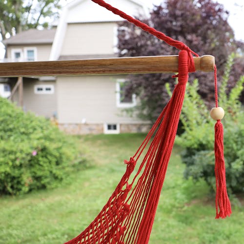 Close-up of the spreader bar and tassel on the Bliss Hammocks 40-inch Red Island Rope Hammock Chair.