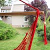 Close-up of the spreader bar and tassel on the Bliss Hammocks 40-inch Red Island Rope Hammock Chair.