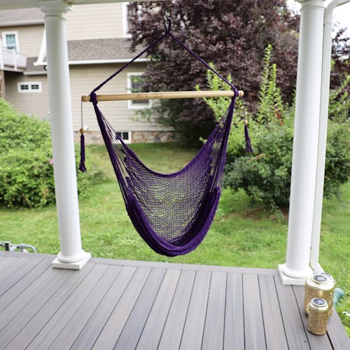 Bliss Hammocks 40-inch Purple Island Rope Hammock Chair hanging on a front porch.