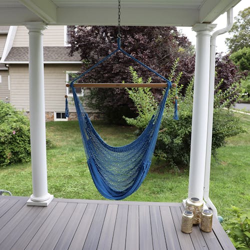 Bliss Hammocks 40-inch Light Blue Island Rope Hammock Chair hanging on a front porch.
