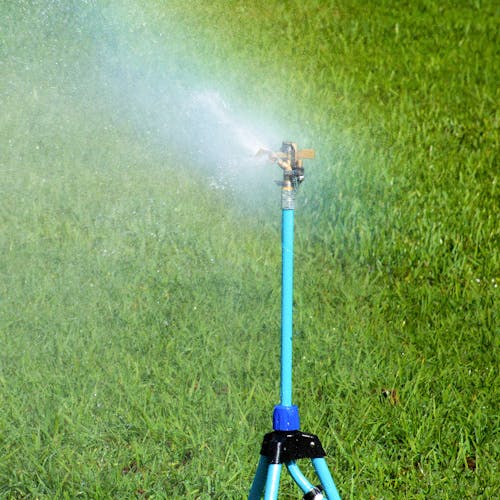 Aqua Joe Indestructible Brass Impulse 360 Degree Sprinkler watering a lawn.