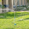 Aqua Joe 3-Arm Brass Rotary 360-Degree Telescoping Sprinkler watering a lawn.