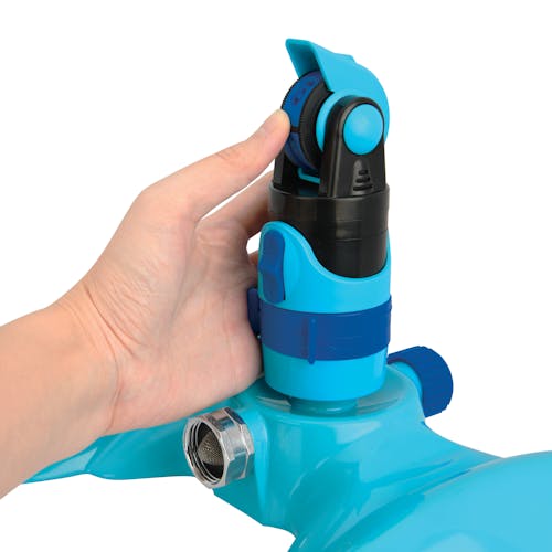 Person adjusting the spray pattern on the Aqua Joe 4-Pattern Turbo Drive 360 Degree Sprinkler.
