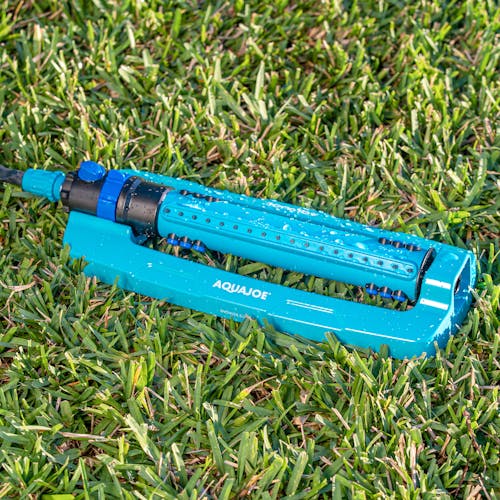 Aqua Joe 20-nozzle Indestructible Metal Base Oscillating Sprinkler sitting in grass.