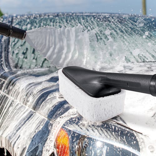 Detailer sponge scrubbing a car.