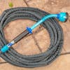 Aqua Joe 18-inch Watering Wand with 10 spray patterns connected to a hose on the ground.