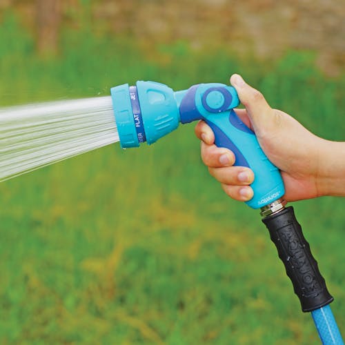 Person spraying water from the Aqua Joe Indestructible Series Non-Slip Grip Hose Nozzle.