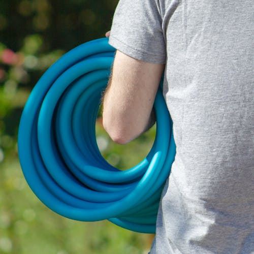 Person holding the Aqua Joe hybrid polymer garden hose on their arm.