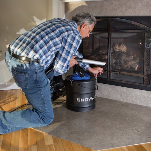 Snow Joe 4.8-gallon Ash Vacuum being used to clean an indoor fireplace.