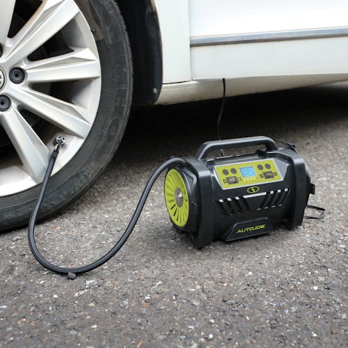 Sun Joe Hybrid 12-Volt/110-Volt AC High Volume Tire Inflator/Deflator being used to inflate a car tire.