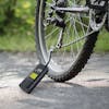 Sun Joe 140 PSI Ultra Compact Cordless Digital Air Pump Inflator and Power Bank being used to fill a bike tire.