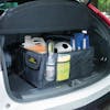 Auto Joe Collapsible Auto Storage Organizer in the trunk of a car filled with a snow broom, soccer ball, cleaning detergent, and more.