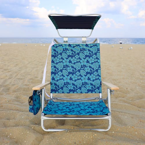Front view of the folding blue flower beach chair with canopy on the beach.