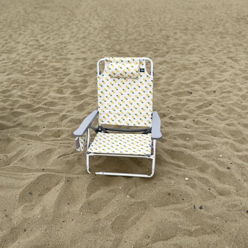 Front view of the folding pineapple beach chair on the sand.