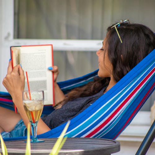 woman laying in Bliss Hammock reading book