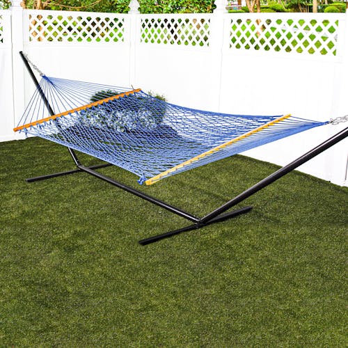 Bliss Hammocks 60-inch Wide Blue Cotton Rope Hammock secured to a stand in a backyard.