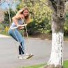 Woman swinging on the Bliss Outdoors Wooden Skateboard Swing.