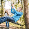 Young man swinging on the Bliss Outdoors Rectangle Tree Swing Glider.