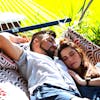 Couple laying in the sun on the 55-inch Red and Grey Quilted Hammock.